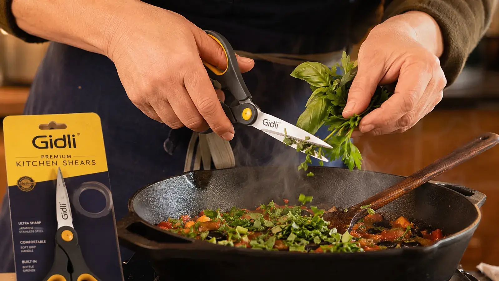 Hands using kitchen shears to snip fresh herbs directly over a cast iron skillet