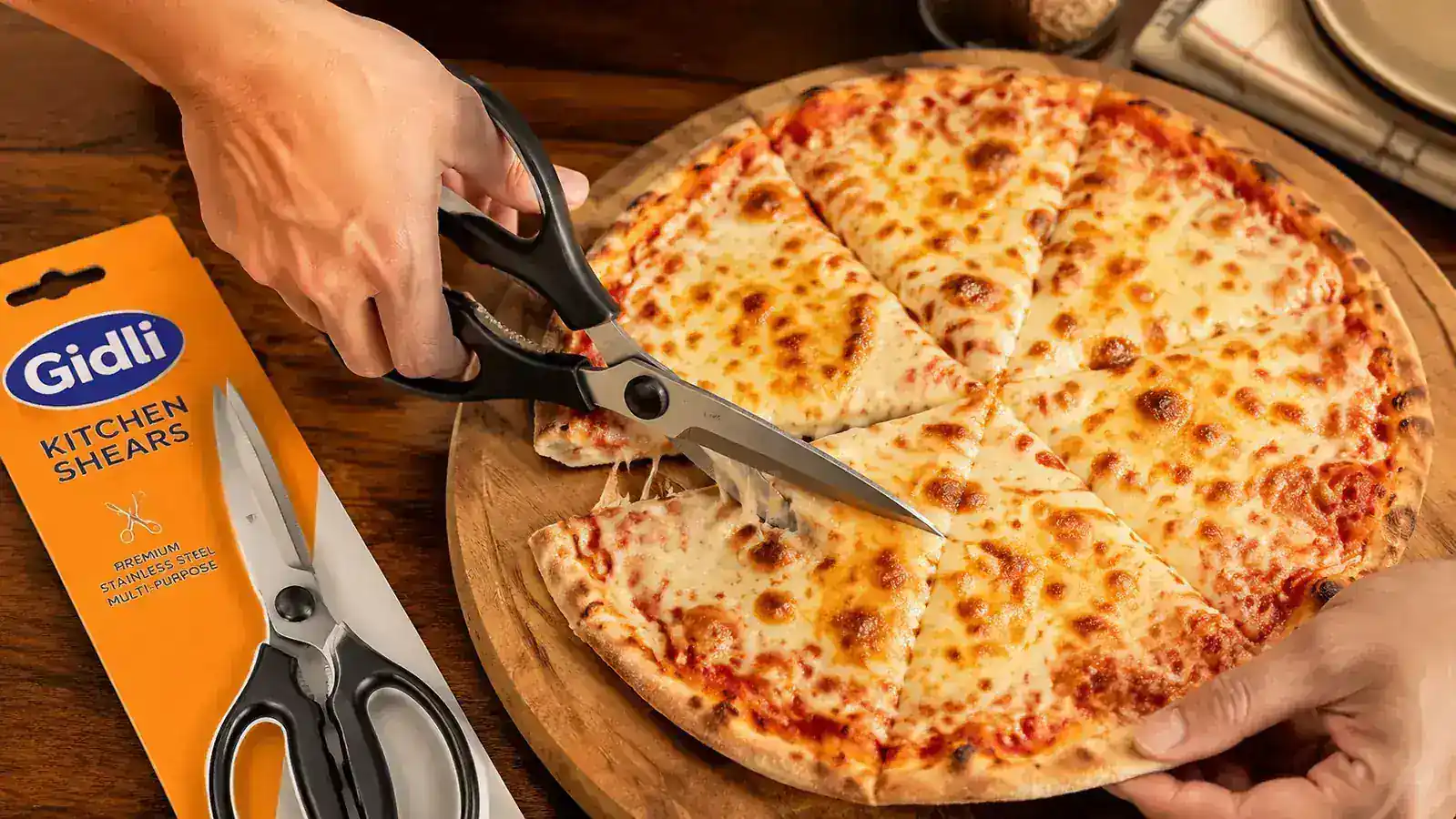 Kitchen shears cutting a slice of pizza on a wooden board, clean cut through cheese and crust